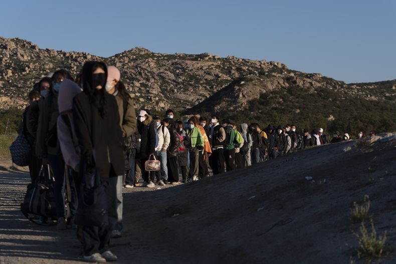 Migrantes chinos esperan ser procesados tras cruzar la frontera con México, el miércoles 8 de mayo de 2024, cerca de Jacumba Hot Springs, California. (AP Foto/Ryan Sun)