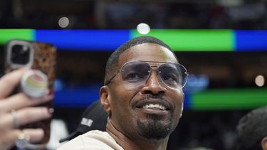 ARCHIVO - El actor Jamie Foxx sonríe durante un partido de la NBA entre los Wizards de Washington y los Mavericks, en Dallas, el sábado 27 de noviembre de 2021. (AP Foto/LM Otero, archivo)