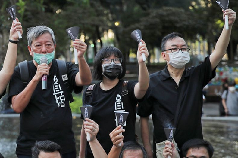 ARCHIVO - De izquierda a derecha, los activistas prodemocracia Lee Cheuk-yan, Chow Hang-tung y Cheung Man-kwong asisten a un acto para recordar a los fallecidos en la represión de Tiananmen de 1989, en el Parque Victoria, en Hong Kong, el 4 de junio de 2020. (AP Foto/Kin Cheung, archivo)
