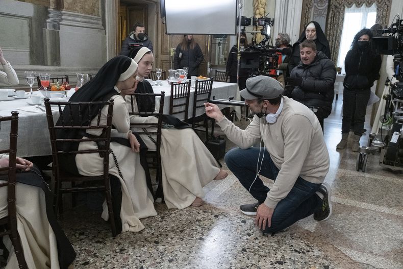 En esta imagen proporcionada por Neon, el director Michael Mohan, de rodillas a la derecha, con la actriz Sydney Sweeney, segunda de izquierda a derecha, en el set de la película Immaculate. (Neon vía AP)