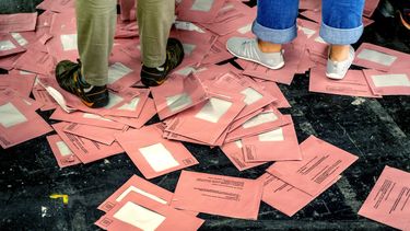 Sobre vacíos de votos por correo en las elecciones europeas se ven en el suelo en una sala durante el conteo electoral de las elecciones europeas, en Fráncfort, Alemania, el domingo 9 de junio de 2024. (AP Foto/Michael Probst)