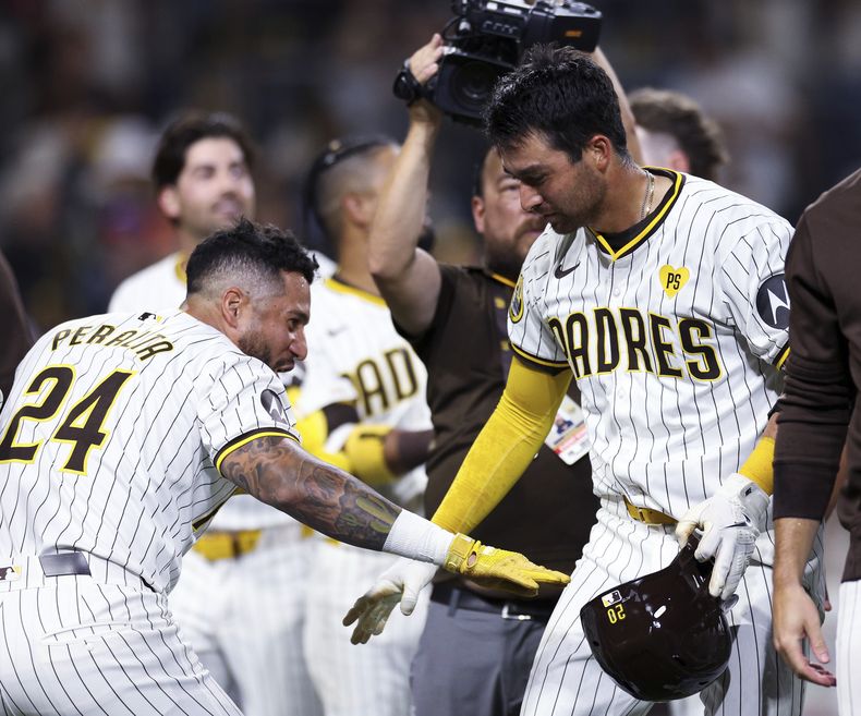 Kyle Higashioka, de los Padres de San Diego, festeja con el venezolano David Peralta luego de batear el jonrón del triunfo ante los Atléticos de Oakland, el martes 11 de junio de 2024 (AP Foto/Derrick Tuskan)