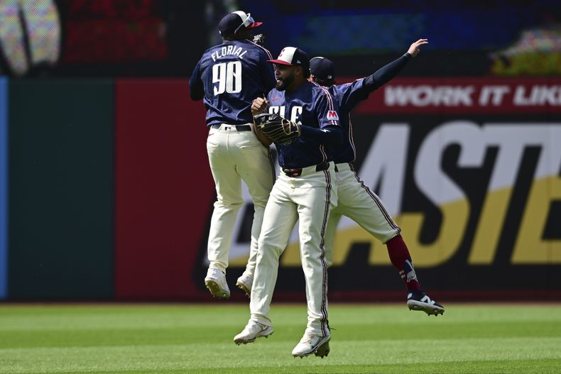 Los jardineros Estevan Florial (90), Johnathan Rodríguez y Tyler Freeman celebran la victoria de los Guardianes de Cleveland ante los Mets de Nueva York, el miércoles 22 de mayo de 2024. (AP Foto/David Dermer)