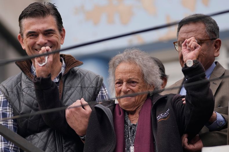 El presidente boliviano Rodrigo Paz, a la izquierda, acompaña a la activista Amparo Carvajal mientras levanta los brazos en la azotea de su oficina en la Asamblea Permanente de los Derechos Humanos de Bolivia (APDHB), después de que el lugar fuera ocupado por grupos afines al MAS, en La Paz, Bolivia, el jueves 20 de noviembre de 2025. (AP Foto/Juan Karita)