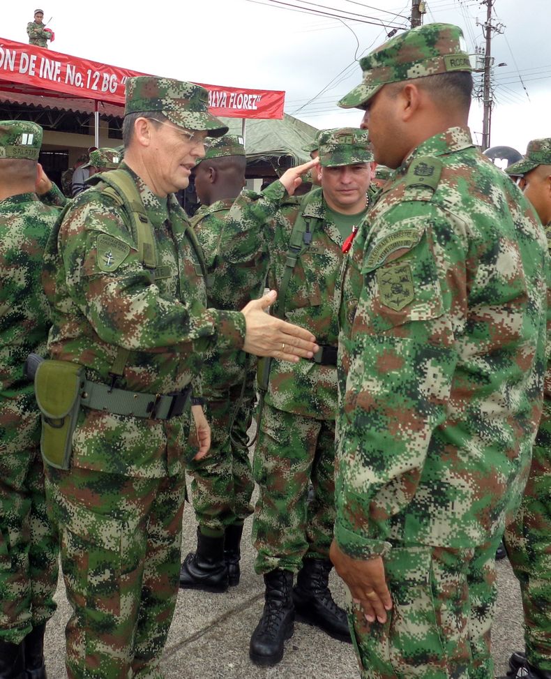 Esta fotograf&iacute;a del 15 de agosto de 2014 difundida por la oficina de prensa del ej&eacute;rcito colombiano muestra al general de esa fuerza Ruben Dar&iacute;o Alzate, a la izquierda, estrechando la mano de un soldado en Colombia. El presidente colo