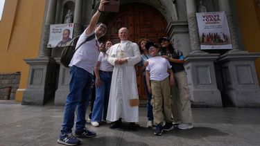 Una familia se toma una selfi con una estatua de tamaño natural del papa León XIV, expuesta frente a una iglesia en el barrio de Barranco, en Lima (Perú), el martes 13 de octubre de 2026, un mes antes de la visita del papa al país. (Foto AP/Martín Mejía)