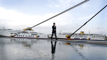 americateve | Una mujer camina frente a barcos amarrados en el puerto del Pireo, cerca de Atenas, durante una huelga general de 24 horas en protesta por medidas de austeridad adicionales, el mi&eacute;rcoles 6 de noviembre de 2013. (AP Foto/Petros Giannakouris)