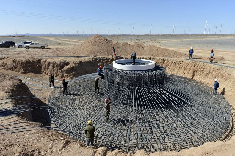 Trabajadores instalan un molino de viento en una granja de energ&iacute;a e&oacute;lica en la regi&oacute;n de Xinjiang, el norte de China, el 10 de abril de 2014. (Foto de AP)