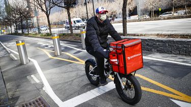 Un repartidor en bicicleta por la autopista West Side, el 16 de marzo de 2020 en Nueva York. (AP Foto/John Minchillo, Archivo)