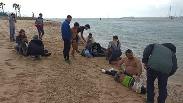 Gente local rescata a migrantes en una playa cerca de Cádiz, España, jueves 30 de noviembre de 2023. Cuatro migrantes murieron a metros de una playa en el sur de España después de ser forzados a bajar del bote en que viajaban, dijeron funcionarios el jueves. La oficina de prensa del gobierno en Cádiz dijo que 31 personas en el bote, incluidos seis menores, sobrevivieron al incidente del miércoles por la tarde y cuatro quedaron hospitalizadas. (AP Foto/Jorge González Casares)