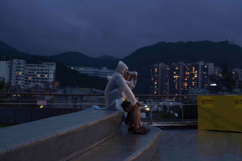 Un hombre toma una cerveza mientras observa cómo rompen las olas en una playa tras el paso del supertifón Ragasa, en Shenzhen, en la provincia china de Guangdong, el 24 de septiembre de 2025. (AP Foto/Ng Han Guan)