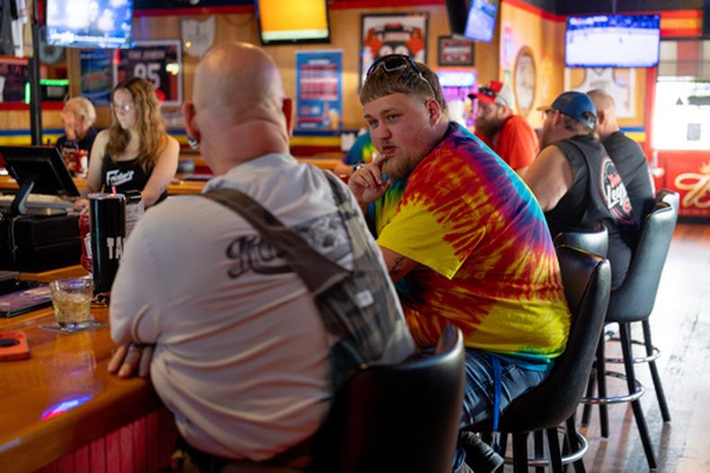 Kyle Bos, derecha, miembro del sindicato United Auto Workers, toma una cerveza con Hal Tank Dunithan, izquierda, y otros miembros del sindicato en el restaurante y bar Frickers en Springfield, Ohio, el miércoles 30 de septiembre de 2026, en el último día de la planta de Navistar en Springfield. (AP Foto/Carolyn Kaster)