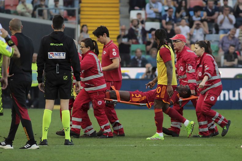 El defensor de la Roma Evan Ndicka es retirado del terreno de juego en camilla durante el partido de la Liga de Italia entre Udinese y la Roma, en el estadio Bluenergy en Udine, Italia, el domingo 14 de abril de 2024. (Andrea Bressanutti/LaPresse via AP)