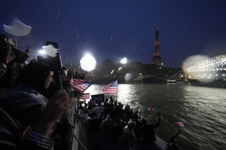 Integrantes del equipo de Estados Unidos navegan el río Sena durante la ceremonia de apertura de los Juegos Olímpicos de París, el viernes 26 de julio de 2024. (AP Foto/Ashley Landis, Pool)