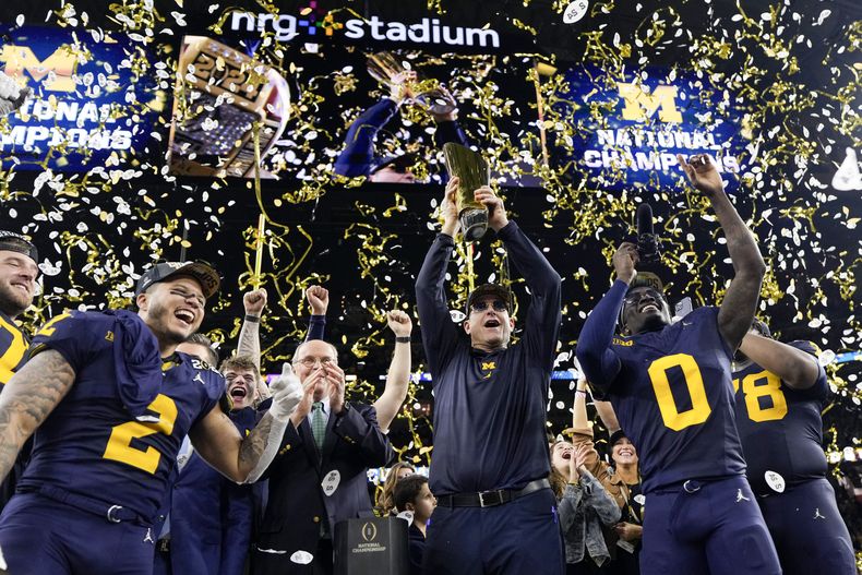 El entrenador de Michigan Jim Harbaugh levanta el trofeo de campeón nacional colegial después de que su equipo superó a Washigton por el título el lunes 8 de enero del 2024. (AP Foto/David J. Phillip)