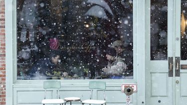 Clientes en el interior de una cafetería mientras nieva en el vecindario de Old City, en Filadelfia, el 19 de enero de 2024. (Yong Kim/The Philadelphia Inquirer vía AP)
