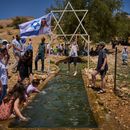 Un niño se cuelga en una estructura metálica con forma de estrella de David sobre un manantial en Auja, en el valle del Jordán, durante el Día de la Independencia de Israel, el 22 de abril de 2026, en la Cisjordania ocupada. (AP Foto/Ohad Zwigenberg)