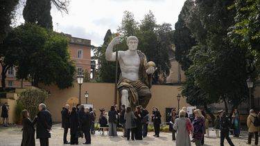Visitantes admiran la réplica de la estatua colosal del emperador romano Constantino, de 13 metros de altura, encomendada por él en 312 d.C. y reconstruida por medio de tecnología 3D a partir de escaneos de las nueve partes originales de mármol que aún existen, al ser develada en Roma el martes 6 de febrero de 2024. (AP Foto/Andrew Medichini)