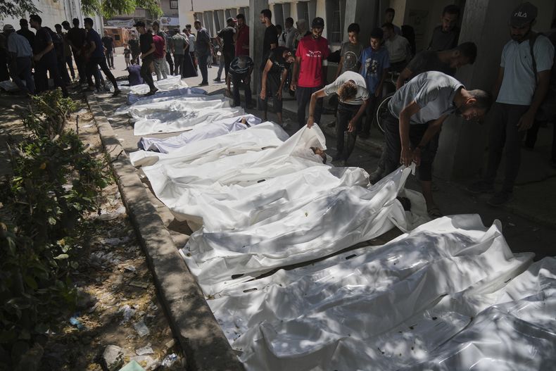 Cuerpos de palestinos asesinados cuando intentaban acceder a camiones de ayuda que llegaron al norte de Gaza por el paso de Zikim con Israel son trasladados a una clínica en Ciudad de Gaza, el domingo, 20 de julio de 2025. (AP Foto/Jehad Alshrafi)