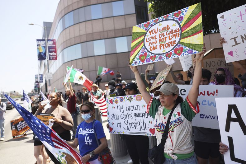 Manifestantes sostienen letreros durante una protesta, el jueves 12 de junio de 2025, en Los Ángeles. (AP Foto/Etienne Laurent)