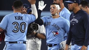 Daulton Varsho, de los Azulejos de Toronto, festeja tras ser embarrado de pastel durante el festejo por la victoria ante los Marineros de Seattle, el sábado 29 de abril de 2023 (Jon Blacker/The Canadian Press via AP)
