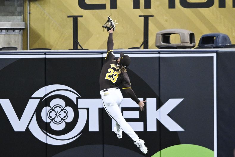 ARCHIVO - El jardinero derecho dominicano de los Padres de San Diego Fernando Tatis Jr. (23) atrapa de un salto un elevado propinado por el dominicano de los Marineros de Seattle Jorge Polanco durante la primera entrada de un juego de pretemporada el lunes 25 de marzo en San Diego. (AP Foto/Denis Poroy, Archivo)