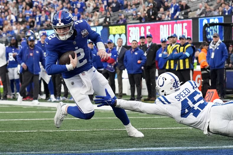 Drew Lock (2), de los Giants de Nueva York, hace un corte y se escapa de E.J. Speed (45), de los Colts de Indianápolis, para lograr un touchdown en un acarreo de cinco yardas en la segunda mitad del partido de la NFL del domingo 29 de diciembre de 2024, en East Rutherford, Nueva Jersey. (AP Foto/Seth Wenig)