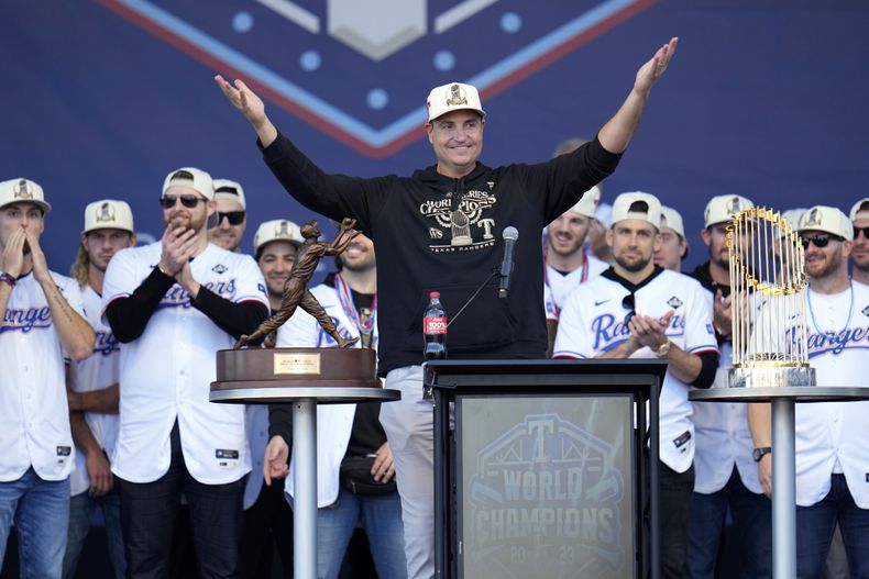 ARCHIVO - Chris Young (centro), gerente general de los Rangers de Texas, habla a los fanáticos durante la celebración del título de la Serie Mundial, el 3 de noviembre de 2023, en Arlington (AP Foto/Julio Cortez, archivo)