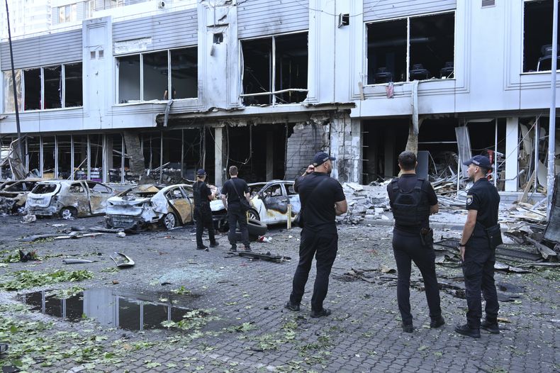 Agentes de policía inspeccionan daños en autos dañados en una zona residencial tras un ataque ruso de dron en Odesa, Ucrania, el martes 22 de julio de 2025. (AP Foto/Michael Shtekel)