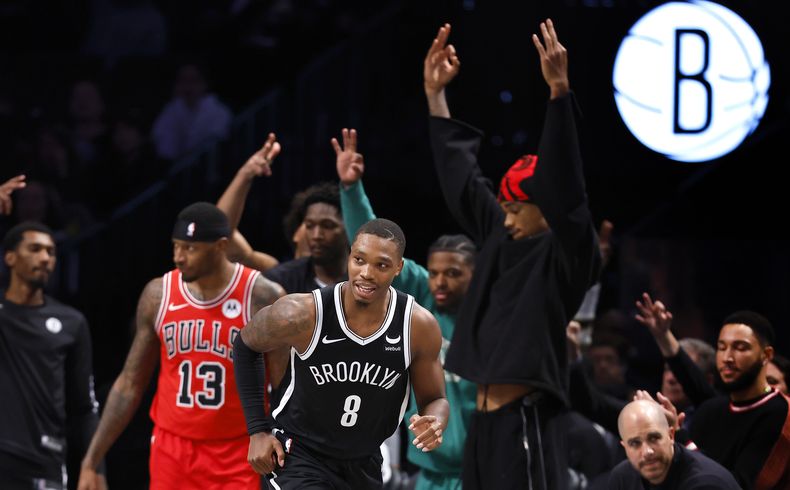 Lonnie Walker IV (8), de los Nets de Brooklyn, reacciona después de embocar un triple en contra de los Bulls de Chicago, con la reacción de Torrey Craig (13), durante la segunda mitad del juego de baloncesto de la NBA, el domingo 26 de noviembre de 2023, en Nueva York. Los Nets ganaron 118-109. (AP Foto/Noah K. Murray)