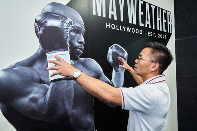 El filipino Manny Pacquiao posa frente a una imagen de Floyd Mayweather Jr. en un gimnasio que le perteneció al segundo y que el primero adquirió, el lunes 6 de abril de 2026, en Hollywood (AP Foto/Damian Dovarganes)