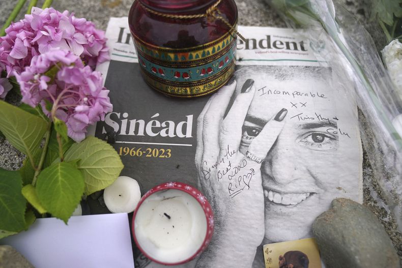 Homenajes florales colocados fuera de la antigua casa de Sinead OConnor en Bray, Co Wicklow, Irlanda, el jueves 27 de julio de 2023 tras su muerte a los 56 años. La Policía Metropolitana dijo que OConnor fue encontrada inconsciente en una casa en el sureste de Londres, donde fue pronunciada muerta. No dijeron cómo falleció, pero dijeron que su muerte no se considera sospechosa. (Brian Lawless/PA vía AP)