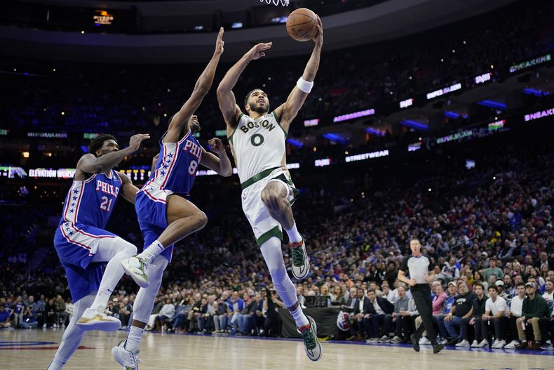 Jayson Tatum, de los Celtics de Boston, salta para encestar frente a DeAnthony Melton (8) y Joel Embiid, de los 76ers de Filadelfia, el miércoles 15 de noviembre de 2023 (AP Foto/Matt Slocum)