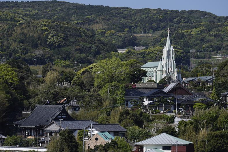 La Iglesia Memorial de San Francisco Javier, al fondo a la derecha, mira hacia los templos budistas Zuiunji, abajo a la izquierda, y Komyoji, frente a la iglesia, en la isla de Ikitsuki, en Hirado, sur de Japón, el martes 29 de abril de 2025. (AP Foto/Hiro Komae)