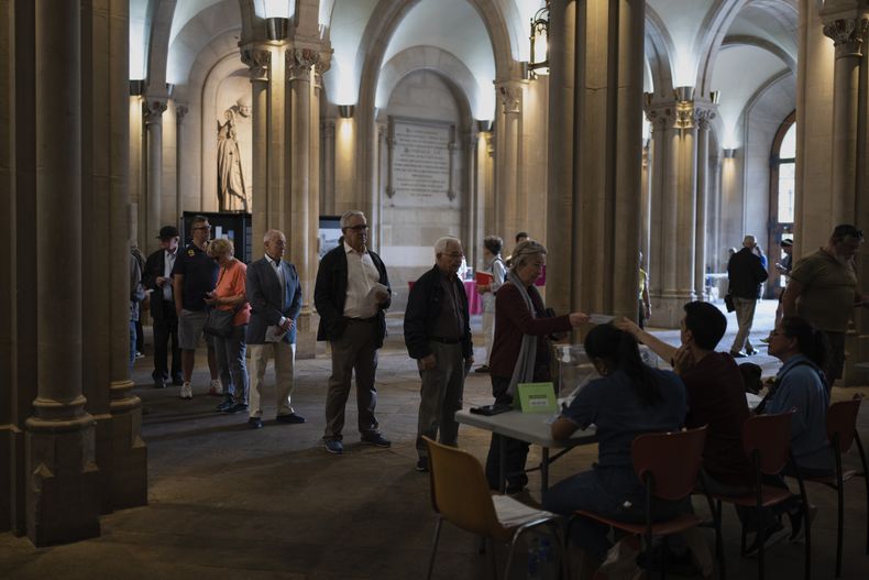 Archivo - Varias personas hacen fila para votar durante las elecciones locales en Barcelona, España, el 28 de mayo de 2023. (AP Foto/Emilio Morenatti, Archivo)
