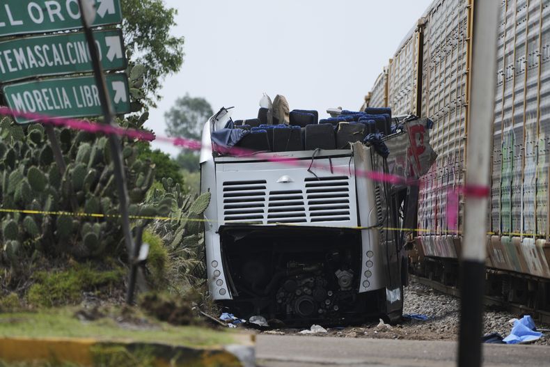 Restos de un autobús de dos pisos se ven junto a un tren de mercancías que lo golpeó en Atlacomulco, México, el lunes 8 de septiembre de 2025. (AP Foto/Fernando Llano)