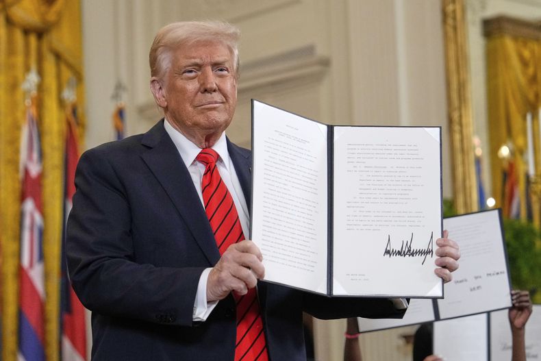 El presidente Donald Trump muestra una orden ejecutiva firmada en un evento de educación en la Sala Este de la Casa Blanca en Washington, el jueves 20 de marzo de 2025. (AP Foto/Ben Curtis)