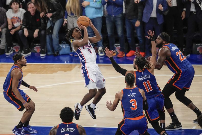 Tyrese Maxey de los 76ers de Filadelfia lanza el balón mientras lo defienden Jalen Brunson, Mitchell Robinson y Josh Hart de los Knicks de Nueva Yorkm en el juego 5 de la serie de primera ronda el martes 30 de abril del 2024. (AP Foto/Frank Franklin II)