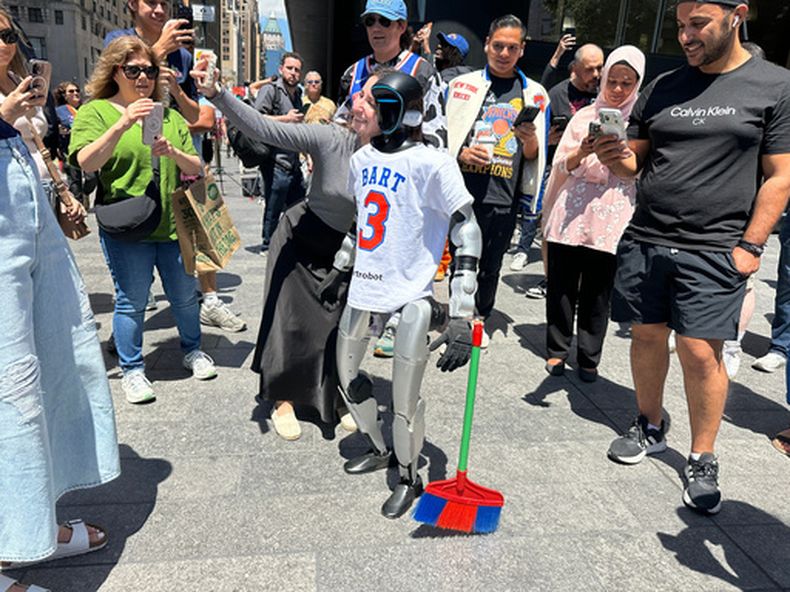 Un aficionado se toma una foto con un robot vestido con un uniforme de los Knicks de Nueva York cerca del Madison Square Garden en Nueva York el lunes 8 de junio del 2026. (AP Foto/Ted Shaffrey)