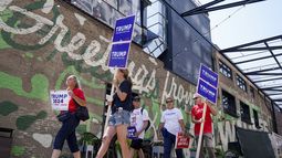Simpatizantes del expresidente Donald Trump caminan cerca del Fiserv Forum, donde se llevará a cabo el primer debate republicano de estas primarias, el martes 22 de agosto de 2023, en Milwaukee. (AP Foto/Morry Gash)