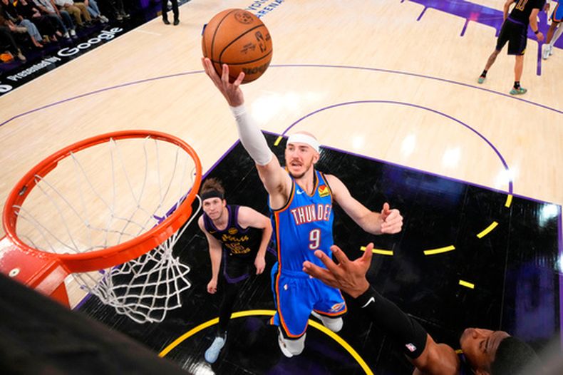 El base del Thunder de Oklahoma City Alex Caruso salta para anotar frente al base de los Lakers de Los Ángeles Austin Reaves y el alero Rui Hachimura en el juego 4 de las semifinales del Oeste el lunes 11 de mayo del 2026. (AP Foto/Mark J. Terrill)