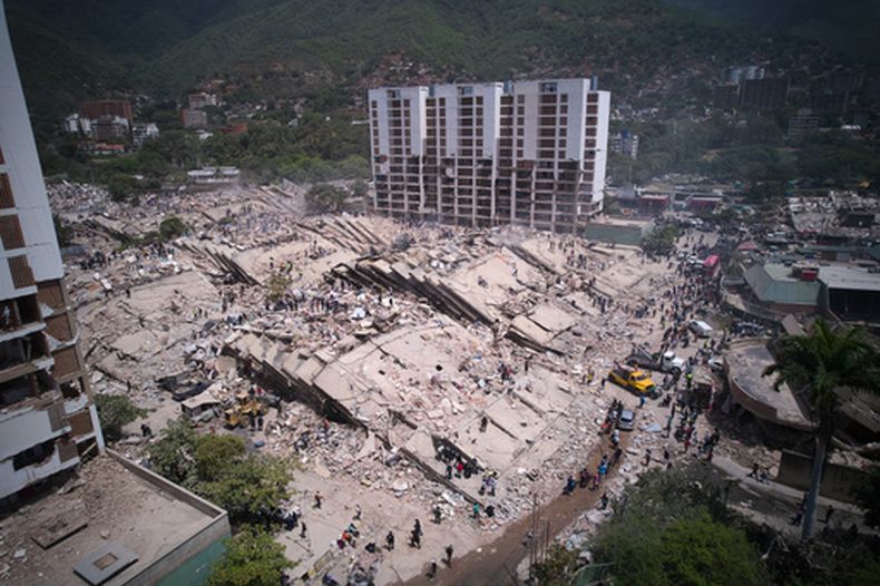 Residentes y rescatistas buscan entre los escombros dos días después de un sismo que remeció La Guaira, Venezuela, el 26 de junio de 2026. (AP Foto/Juan Pablo Arraez)