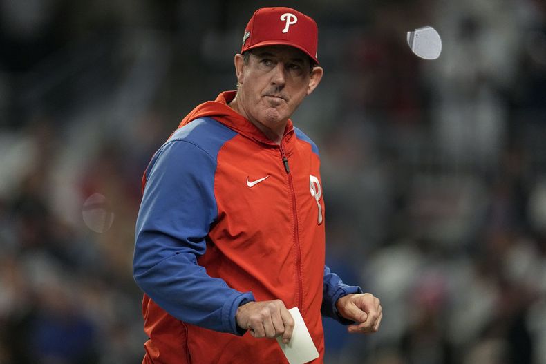 El mánager de los Filis de Filadelfia Rob Thomson camina hacia el banquillo luego de cambiar a un lanzador en la 7ma entrada del Juego 2 de la Serie Divisional de la Liga Nacional ante los Bravos de Atlanta, el lunes 9 de octubre de 2023, en Atlanta. (AP Foto/John Bazemore)