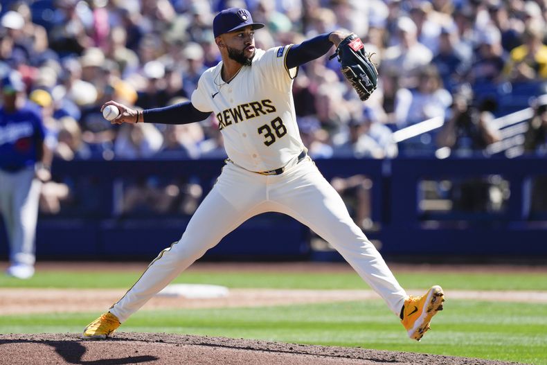 El cerrador de los Cerveceros de Milwaukee Devin Williams lanza en la tercera entrada del juego de los entrenamientos de primavera ante los Dodgers de Los Ángeles el sábado 2 de marzo del 2024. (AP Foto/Carolyn Kaster)