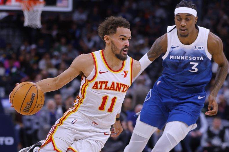 Trae Young (11), de los Hawks de Atlanta, trabaja alrededor de Jaden McDaniels (3), de los Timberwolves de Minnesota, duarnte el tercer periodo del juego de baloncesto de la NBA, el viernes 12 de abril de 2024, en Minneapolis. (AP Foto/Bruce Kluckhohn)