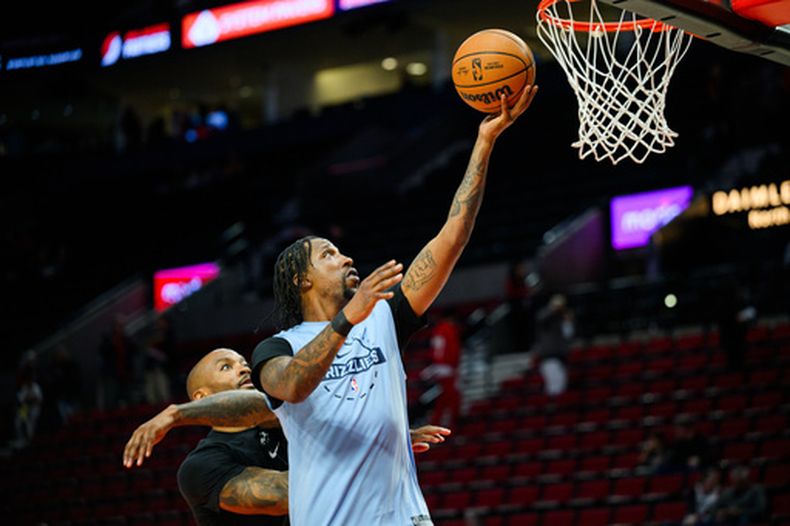 ARCHIVO - El escolta de los Grizzlies de Memphis, Kentavious Caldwell-Pope (derecha), calienta antes de un partido de baloncesto de la NBA contra los Trail Blazers de Portland, el viernes 6 de febrero de 2026, en Portland, Oregón. (Foto AP/Molly J. Smith, Archivo)