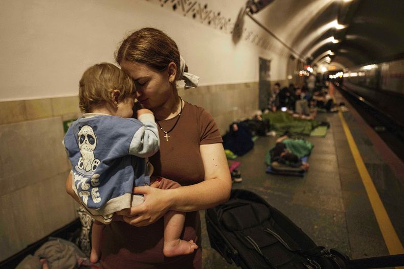 Oleksandra Umanets, de 23 años, calma a su hijo de 10 meses mientras se refugian en el andén de una estación de metro durante un ataque ruso sobre Kiev, Ucrania, el 10 de julio de 2025. (AP Foto/Evgeniy Maloletka)