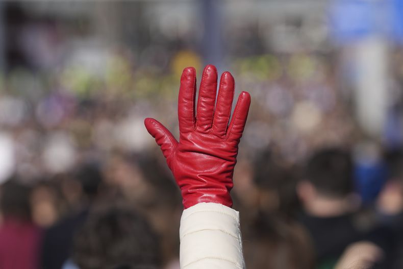Una mujer levanta un guante rojo que simboliza la sangre durante una protesta estudiantil que bloqueó durante 24 horas una intersección, para protestar por la muerte de 15 personas por la caída de una cornisa en una estación de tren en noviembre, en Belgrado, Serbia, el 27 de enero de 2025. (AP Foto/Darko Vojinovic)