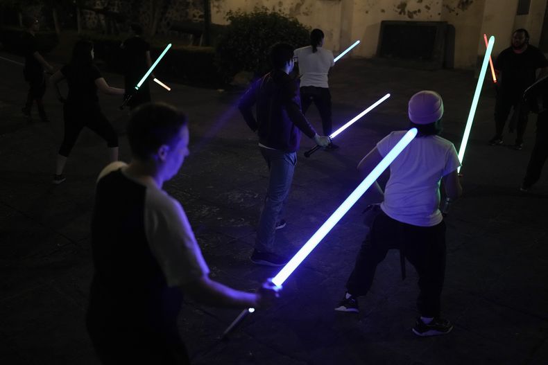 Estudiantes de la Jedi Knight Academy aprenden cómo usar sables láser en un parque de la Ciudad de México, el jueves 20 de junio de 2024. (AP Foto/Eduardo Verdugo)