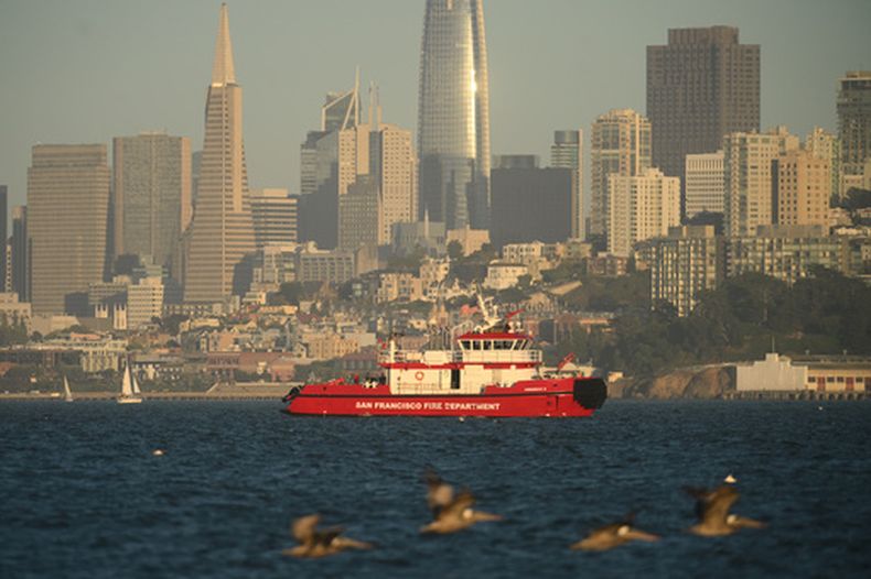 Una embarcación de los bomberos de San Francisco pasa delante de la ciudad mientras busca personas desaparecidas tras un naufragio cerca de la isla de Alcatraz, cerca de San Francisco, el martes 14 de julio de 2026. (AP Foto/Noah Berger)